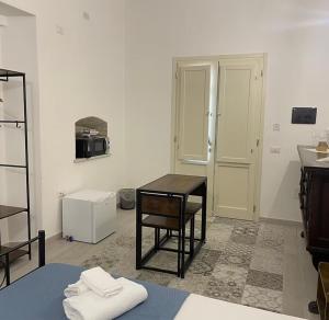 een kamer met een tafel en stoelen en een magnetron bij Luxar Suites and Apartments in Assemini