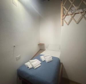 een kleine kamer met een blauw bed met handdoeken erop bij Luxar Suites and Apartments in Assemini +96 foto's