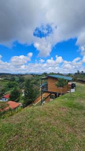 a building on top of a grassy hill at Cabaña Martina con Jacuzzi in Marinilla