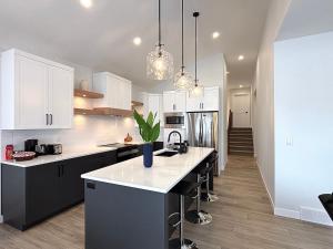 a kitchen with white cabinets and a kitchen island at Cozy Heaven in Saskatoon