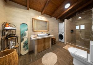 un bagno con lavandino e tavola da surf sul muro di Villa Dianne Apt 1 Livadi Arachovas ad Aráchova