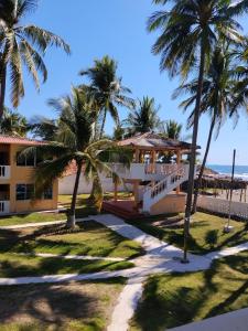 een huis aan het strand met palmbomen bij Hotel y Restaurante Punta Corona in Acajutla