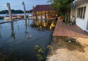 a body of water with a house and a dock at Kampot Riverside GuessHouse in Phumĭ Ândong Pring