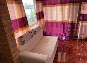 a white couch sitting in front of a window at Kampot Riverside GuessHouse in Phumĭ Ândong Pring