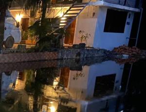 a reflection of a house in the water at night at Kampot Riverside GuessHouse in Phumĭ Ândong Pring