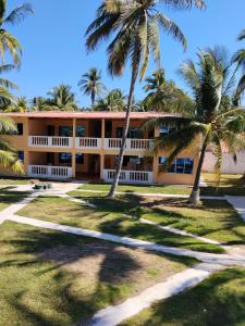 een gebouw met palmbomen ervoor bij Hotel y Restaurante Punta Corona in Acajutla