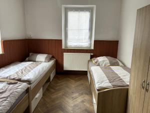 due letti in una piccola stanza con una finestra di Gasthaus Wipfler a Villenbach