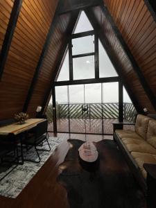 a living room with a large window and a couch at Chalé das pedras in Massaranduba