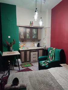 un soggiorno con un divano verde e una cucina di La Familia a Veria