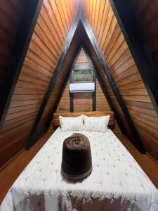 a bed in a room with a roof at Chalé das pedras in Massaranduba