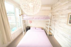 a small bedroom with a bunk bed and a chandelier at Yume House in Furano