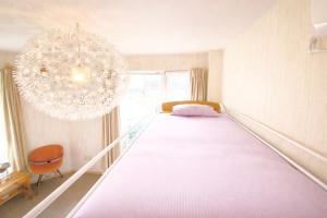 een groot bed in een kamer met een kroonluchter bij Yume House in Furano