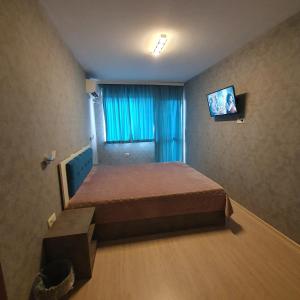 ein kleines Schlafzimmer mit einem Bett und einem Fernseher in der Unterkunft Lake View Deluxe Tryavna in Trjawna