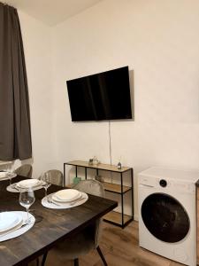 a dining room with a table and a tv on the wall at Gemütliche 3-Zimmer-Wohnung mit Parkplatz in Itzehoe