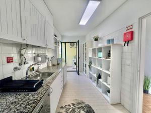 een keuken met witte kasten en een spoelbak bij View in Bicas