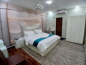 a bedroom with a large bed with a painting on the wall at Prime Star Hotel in Karachi