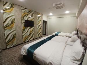 a bedroom with a large bed and a painting on the wall at Prime Star Hotel in Karachi +16 photos