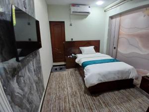a hotel room with two beds and a tv at Prime Star Hotel in Karachi