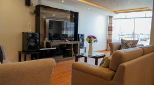 a living room with two couches and a television at Hotel Killasumaq in Cajamarca