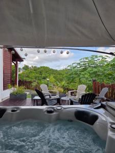 a hot tub with chairs and tables on a patio at Les hauts de beline Salines in Le Gosier
