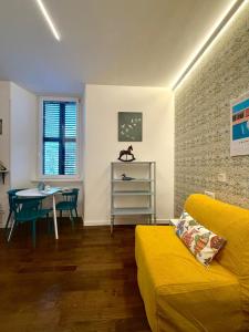 a living room with a yellow couch and a table at Old Town Nest in Civitavecchia in Civitavecchia
