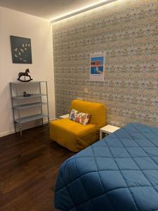 a bedroom with a bed and a yellow chair at Old Town Nest in Civitavecchia in Civitavecchia +102 photos