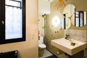 ein Badezimmer mit Waschbecken, Toilette und Spiegeln in der Unterkunft Studio design Pigalle Montmartre in Paris