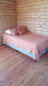 Verde Oliva في فيديراسيون: سرير في غرفة ذات جدار خشبي