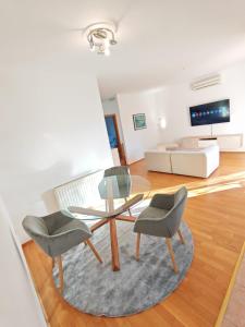 een woonkamer met een tafel, stoelen en een bank bij Happy Point in Krk