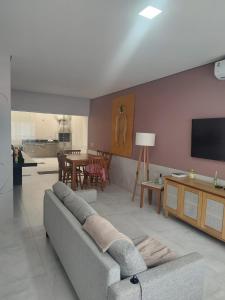 a living room with a couch and a tv at Casa com 3 suítes em Juquehy in São Sebastião