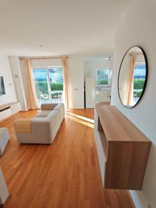 een woonkamer met een bank en een spiegel bij Happy Point in Krk