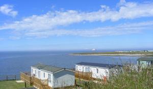 a row of houses next to a body of water at Rendezvous at Ocean Edge in Heysham