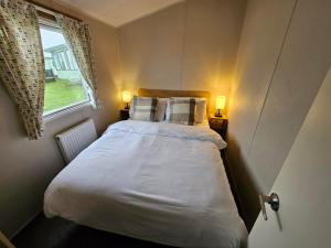 a bed in a small room with two lamps at Rendezvous at Ocean Edge in Heysham