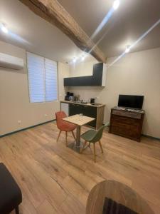 een woonkamer met een tafel en stoelen en een keuken bij Le Figuier - Studio de Charme in Lavaur