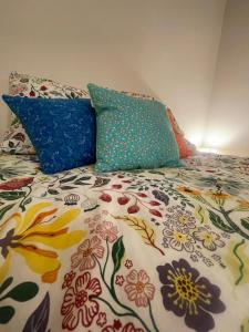 een bed met kleurrijke kussens erop bij Le Figuier - Studio de Charme in Lavaur