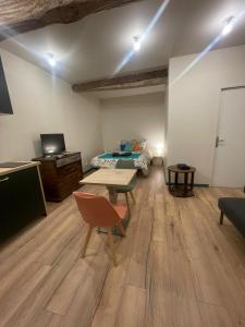 een kamer met een kamer met een bed en een tafel bij Le Figuier - Studio de Charme in Lavaur