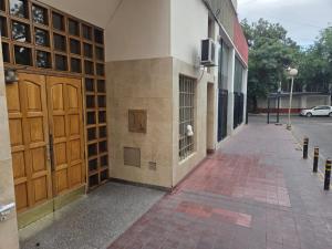 a building with brown doors and a brick sidewalk at Amplio Departamento Céntrico in Barraquero