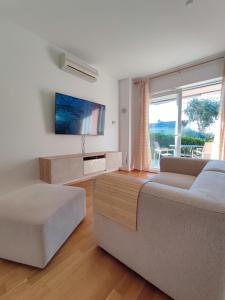 een woonkamer met een bank en een tv bij Happy Point in Krk