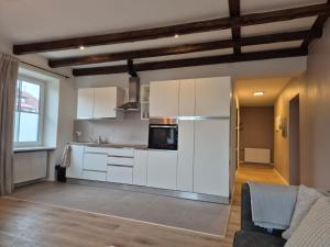 een keuken met witte kasten en een bank in een kamer bij Haus Waldbach - nahe Nassfeld - Pressegger See in Köstendorf