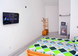 ein Schlafzimmer mit Bett und Flachbildfernseher in der Unterkunft Studios cosy in Aoudja