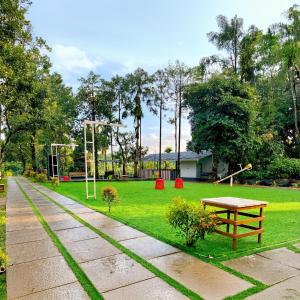 a park with a picnic table and a playground at Nellar Dream Resort in Meppādi