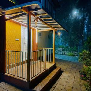 a pergola on a porch of a house at night at Nellar Dream Resort in Meppādi