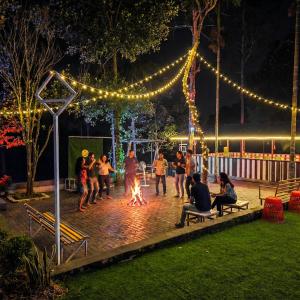a group of people dancing around a fire in a park at night at Nellar Dream Resort in Meppādi