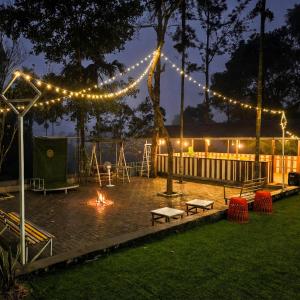 a backyard with a fire pit and lights at night at Nellar Dream Resort in Meppādi