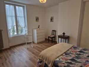 een slaapkamer met een bed, een ladekast en een raam bij Le rempart in Chalon-sur-Saône