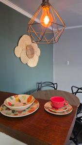 a table with plates and bowls on top of it at Casa completa, lindamente decorada, nova com 2 quartos in São Gabriel