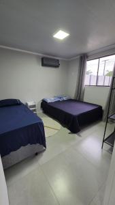 a bedroom with two beds and a window at Casa completa, lindamente decorada, nova com 2 quartos in São Gabriel