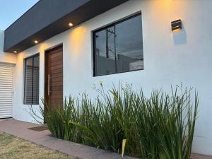 a white house with a window and some plants at Casa completa, lindamente decorada, nova com 2 quartos in São Gabriel +8 photos