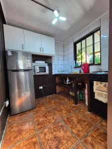 een keuken met een roestvrijstalen koelkast en een tegelvloer bij Ironhause in Pucón +8 foto's