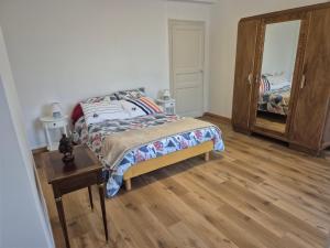 een slaapkamer met een bed, een ladekast en een spiegel bij Le rempart in Chalon-sur-Saône